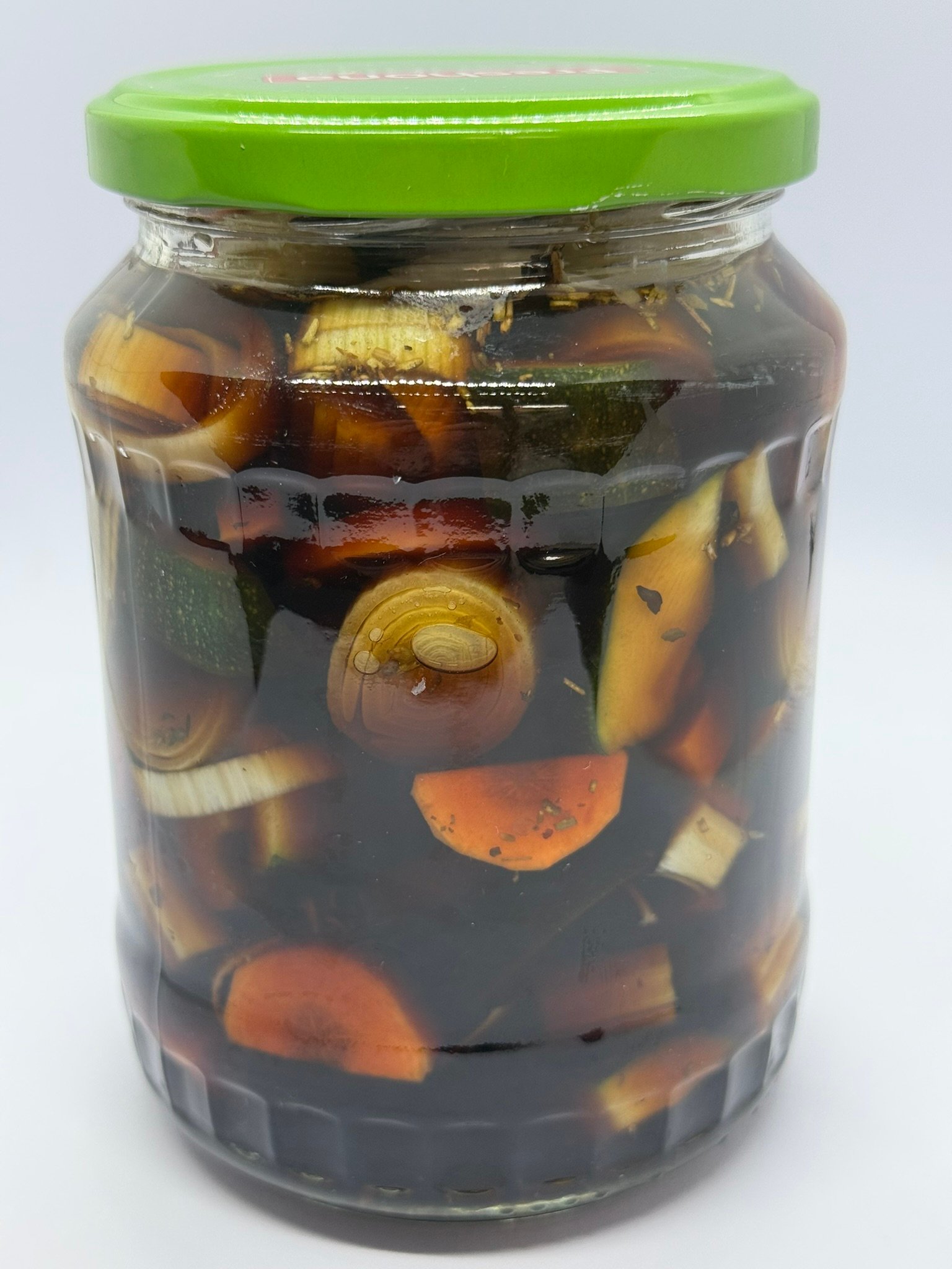 Kleurrijke groenten zoals bloemkool, wortel en ui in een donkerrode marinade van balsamicoazijn in een weckpot.