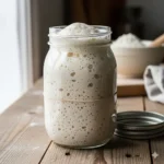 Actieve zuurdesem starter in een glazen pot, de microbiële basis voor alle RootsDough broodrecepten.